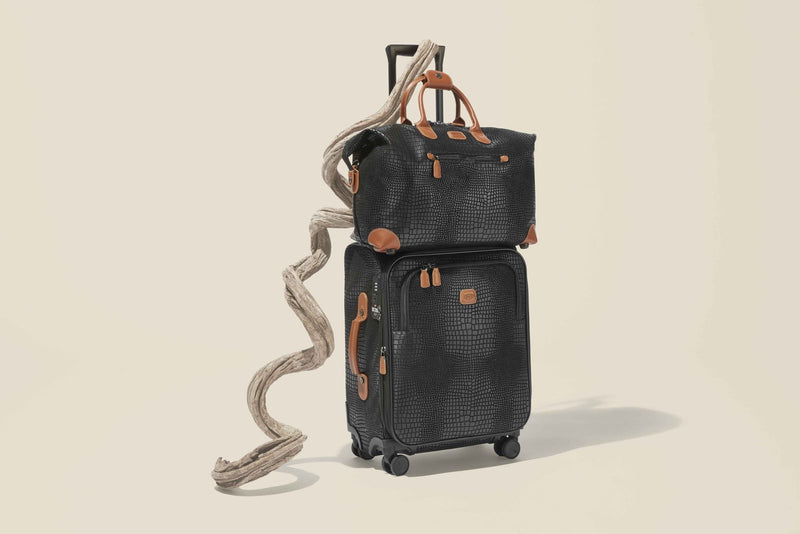 Black Bric's My Safari cargo duffle sitting on top of a matching My Safari carry-on spinner